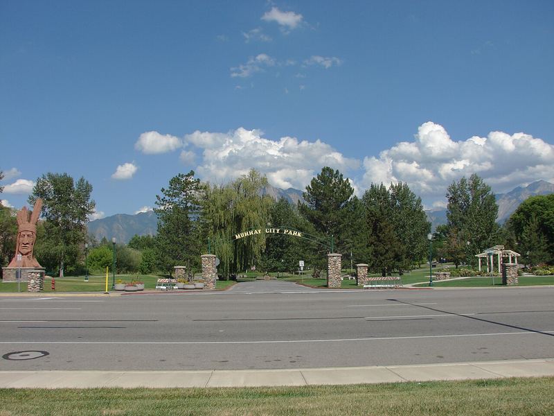 Murray City Park entrance arch on State Street with Wasatch Mountains in the distance