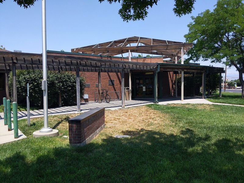 Taylorsville Library entrance with wooden pergola and green lawn, Taylorsville, Utah